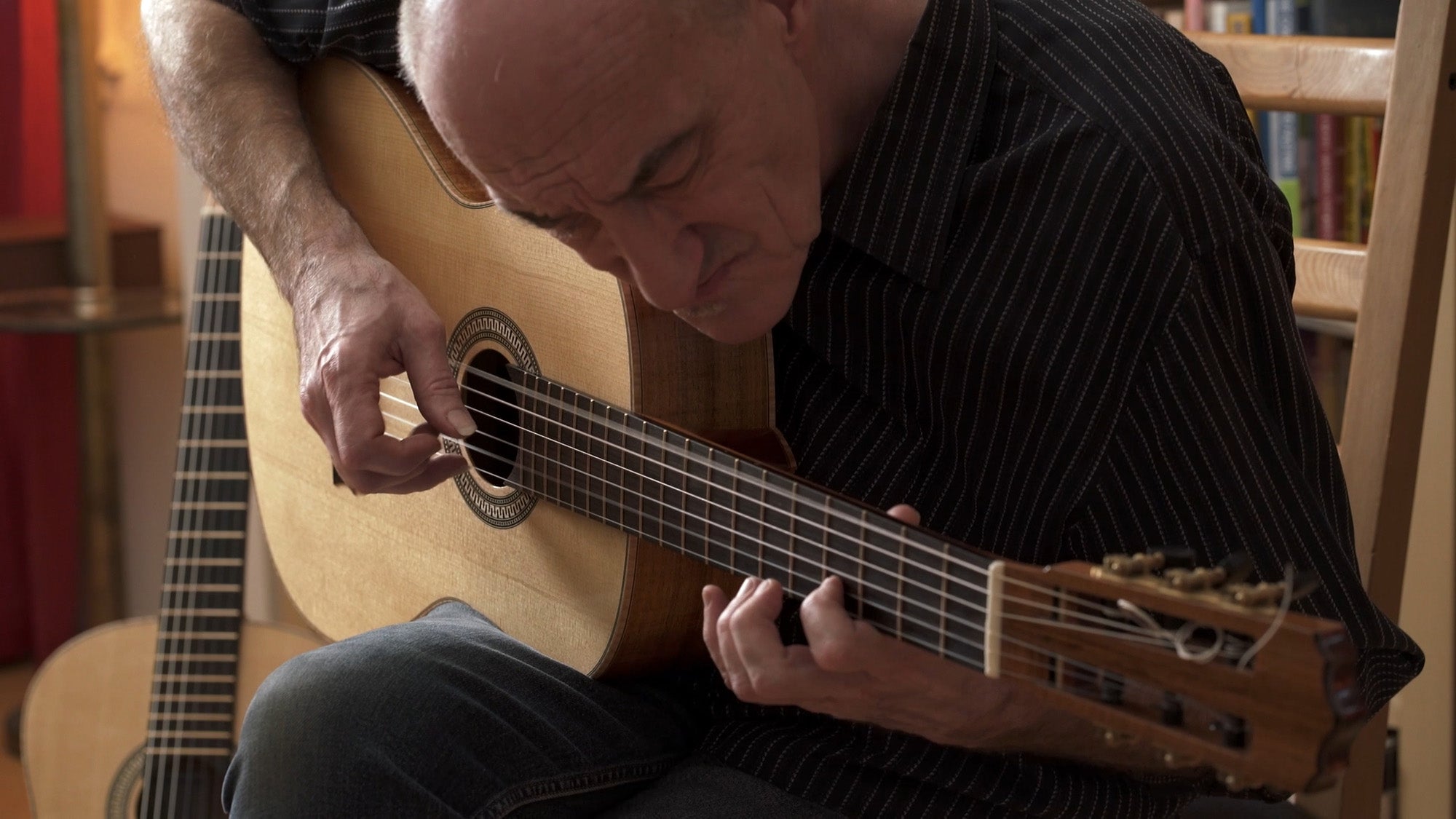 Miroslav Tadić playing a classical guitar, closely focused on tone and dynamics during a seated performance.