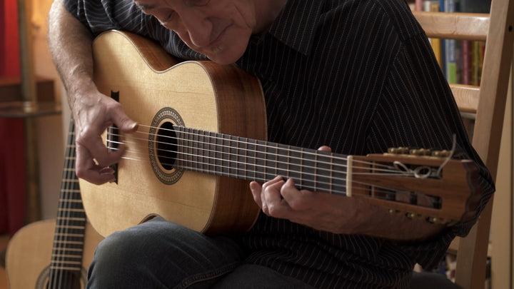Miroslav Tadic is playing a handmade acoustic guitar, demonstrating the tone and playability of a premium Pacific Rim Tonewoods soundboard.