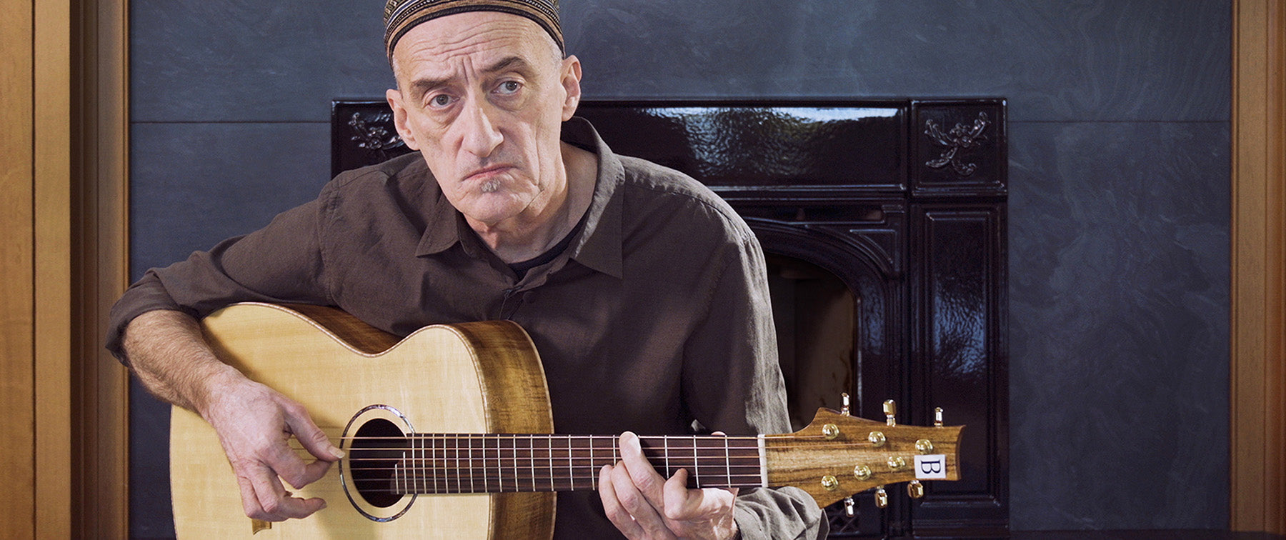 Close-up of Miroslav Tadić playing a classical guitar, overlaid with the text “In Conversation: The Science Behind Building Better Guitars.”