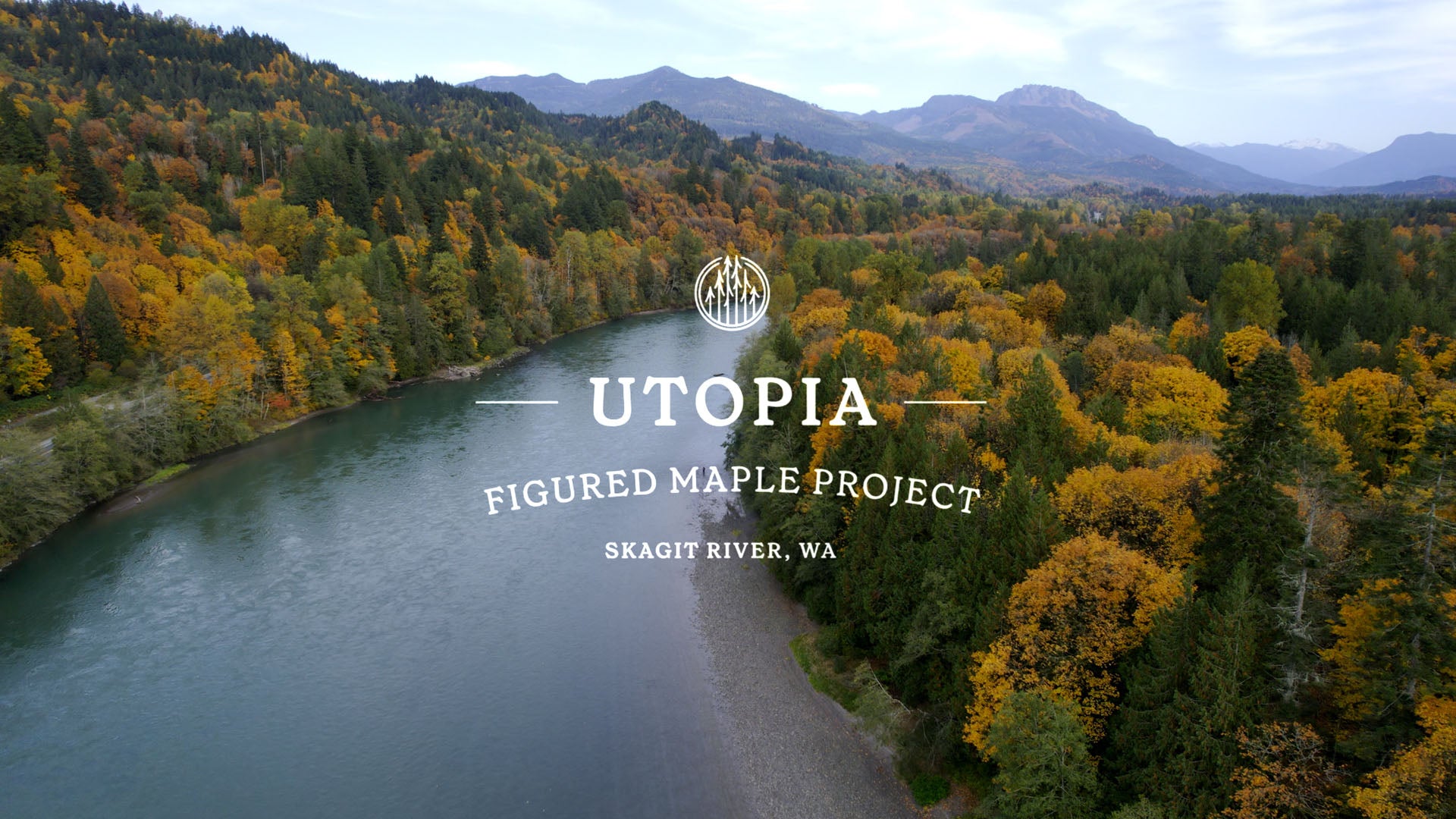 Aerial view of the Skagit River surrounded by autumn forests, overlaid with the Utopia Figured Maple Project logo.