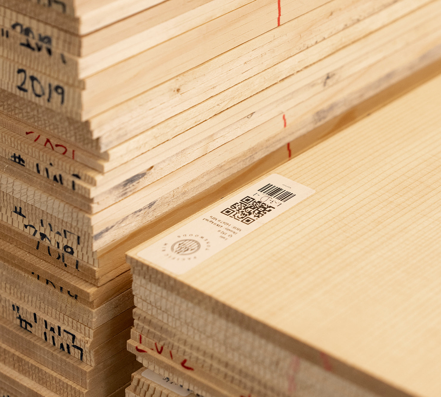 Stack of sonically graded spruce top sets with PRT barcode and tracking label. Clean, tight grain visible on front plate.